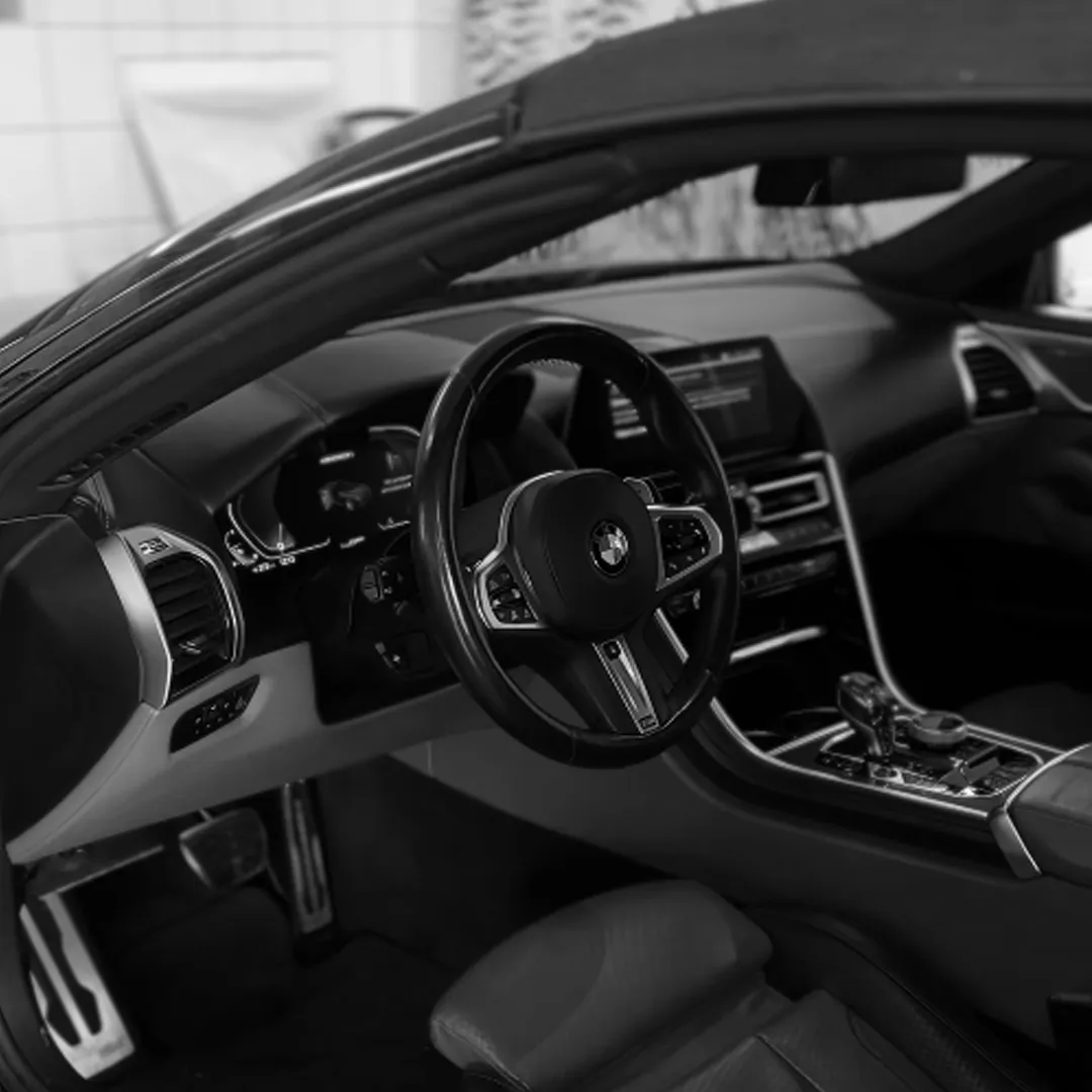 Wnętrze BMW po detailingu — kierownica, deska rozdzielcza i konsola środkowa.