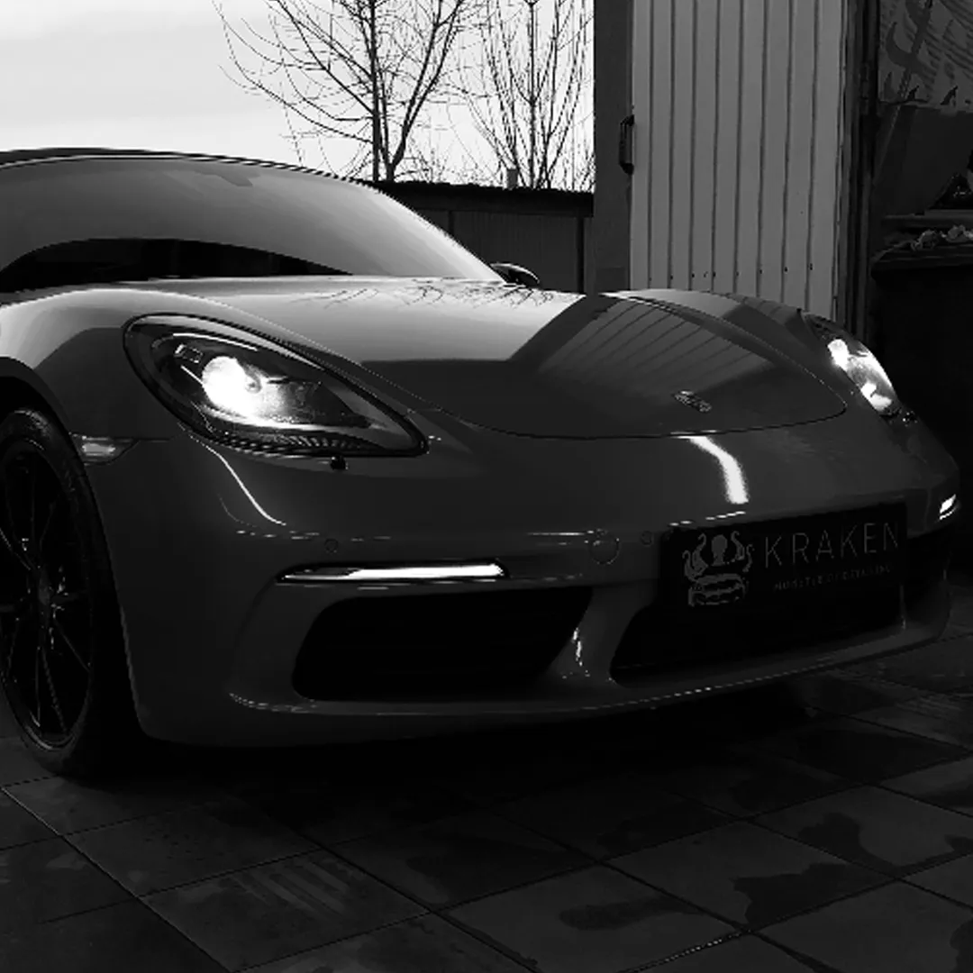 Porsche z włączonymi światłami po zabiegu ochrony lakieru w Krakowie.