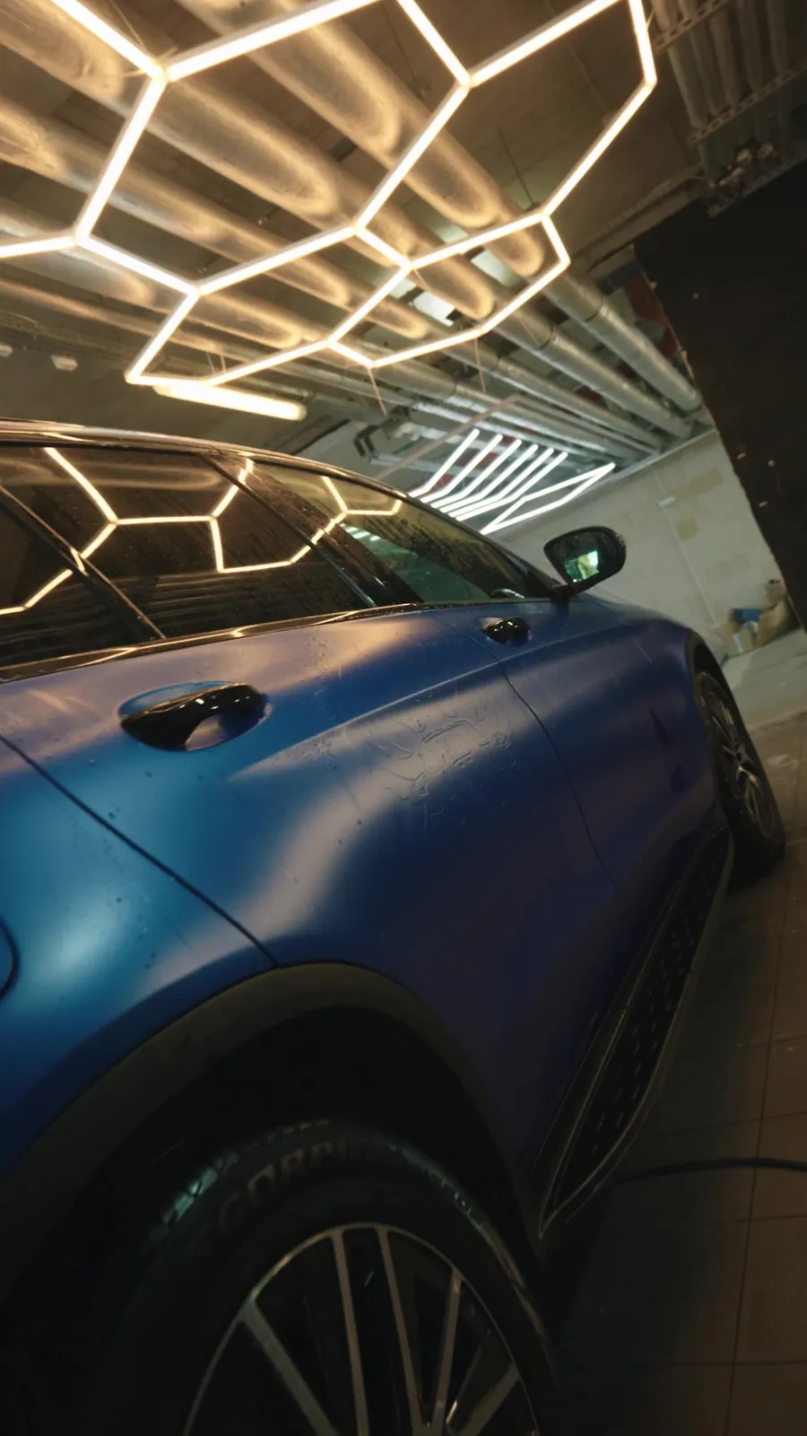 Kraken Detailing studio at ul. Powstańców 20, car in a bay under hex lighting